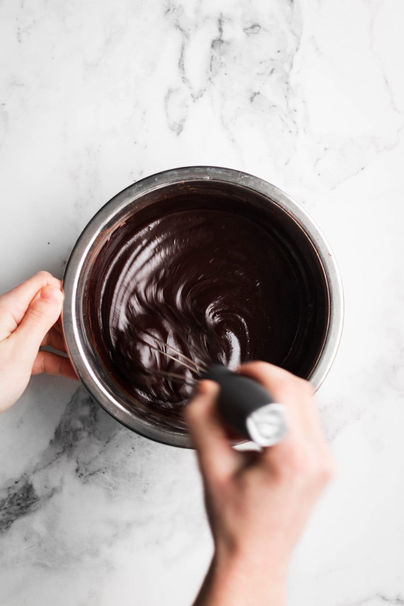 hands mixing chocolate mixture in a bowl