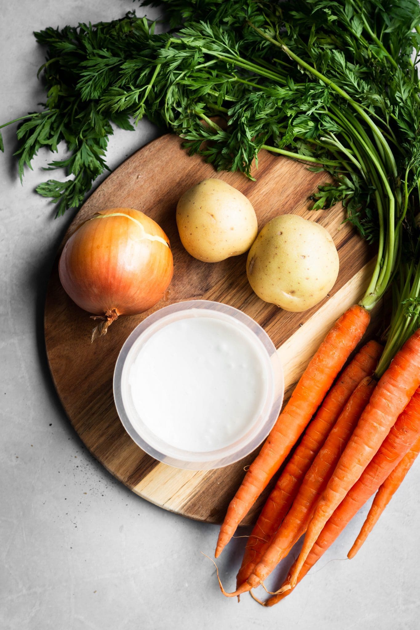 carrots, onion, coconut milk and potatoes on a cutting board