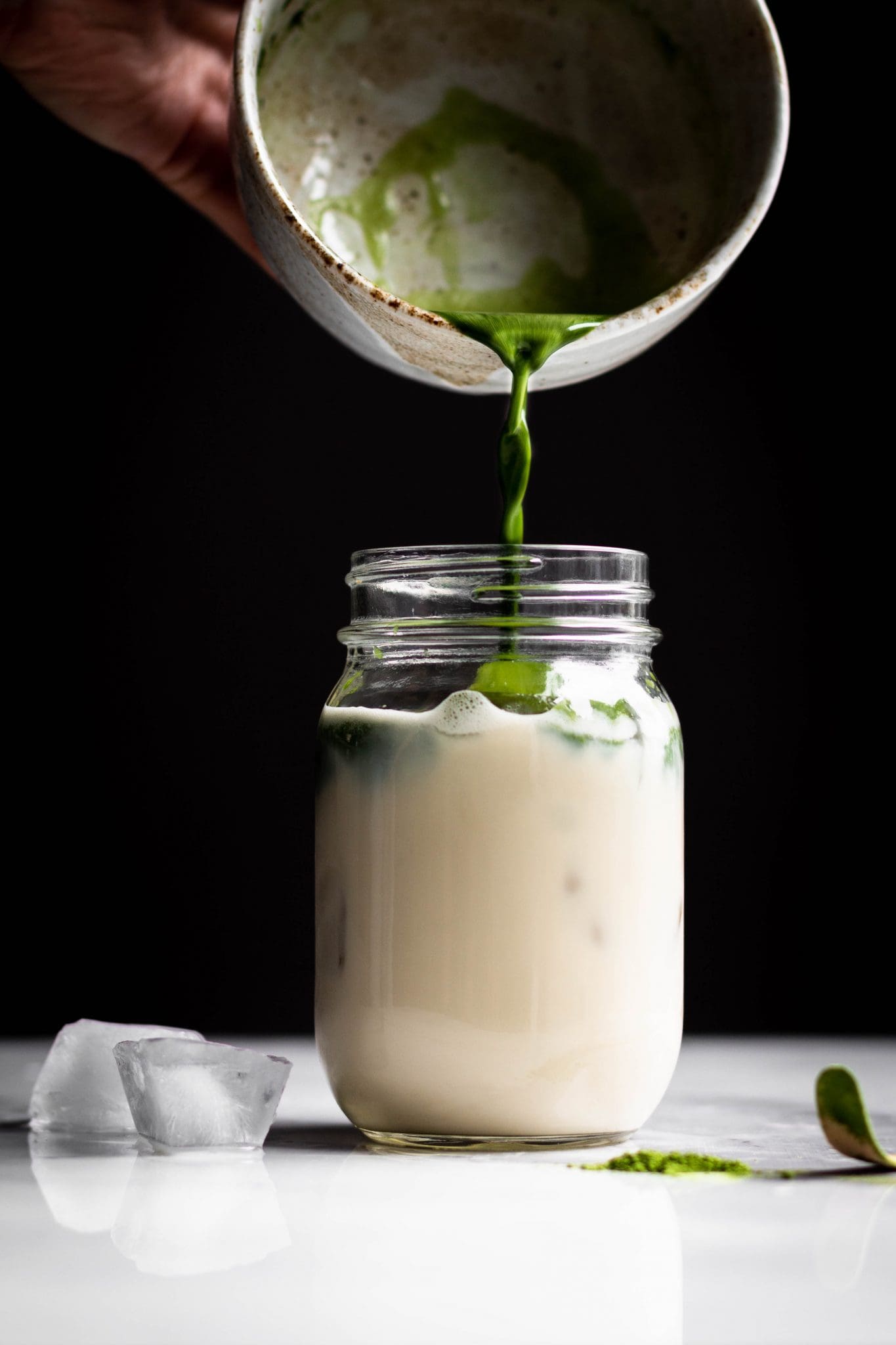 matcha poured in a jar with ice and oat milk