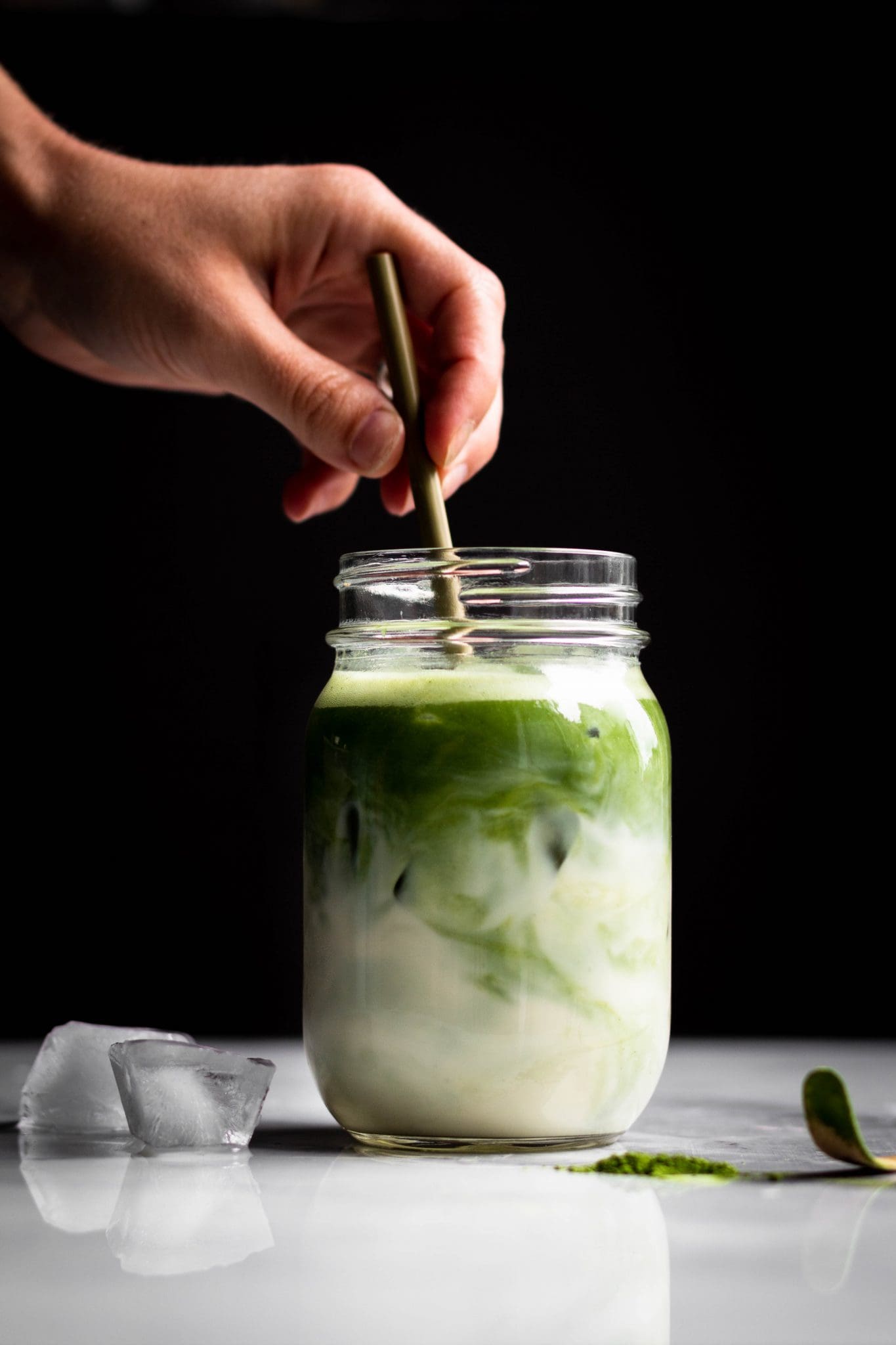 matcha swirled in a jar with ice and oat milk