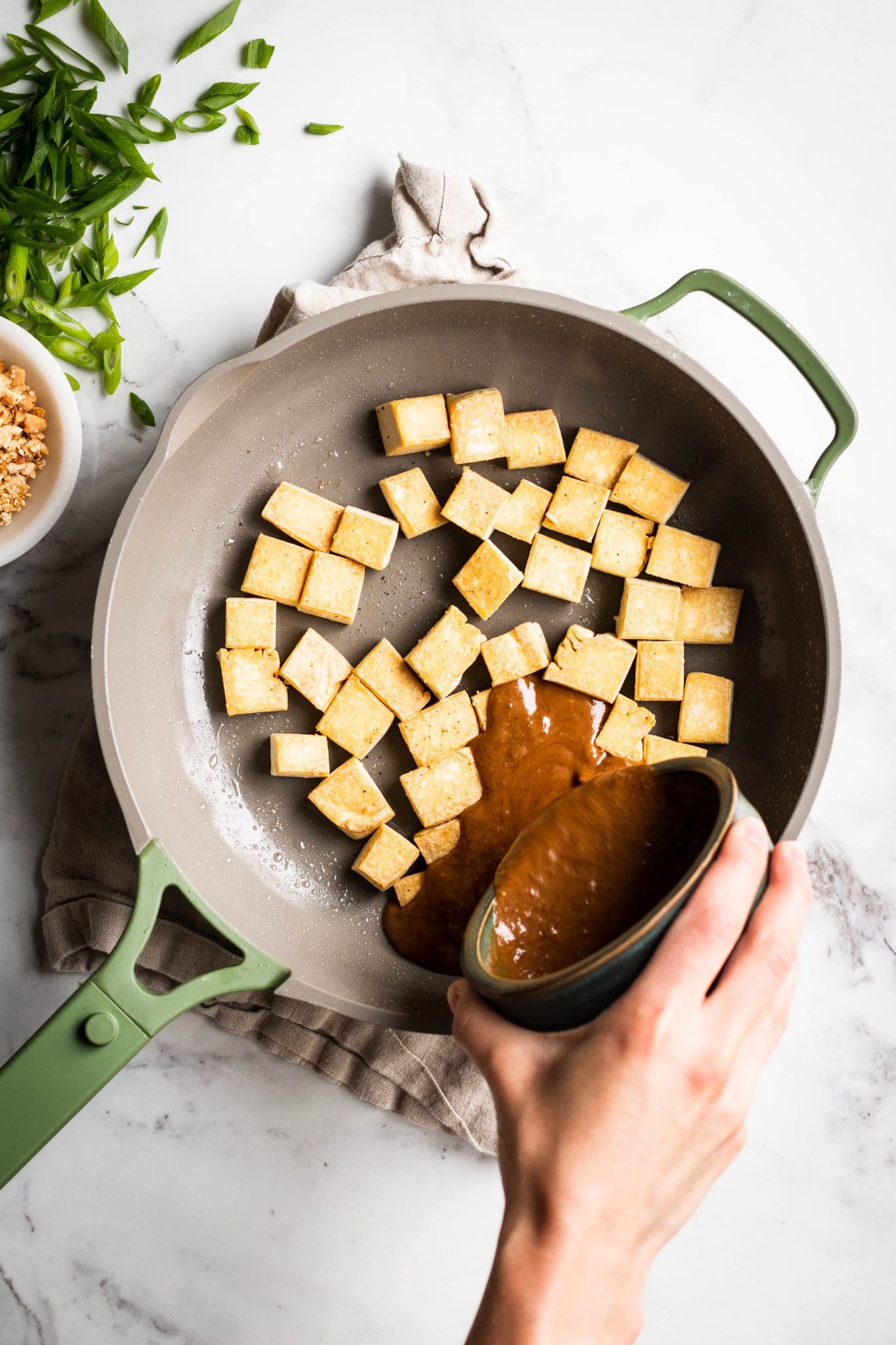 sauce poured over tofu in a skillet