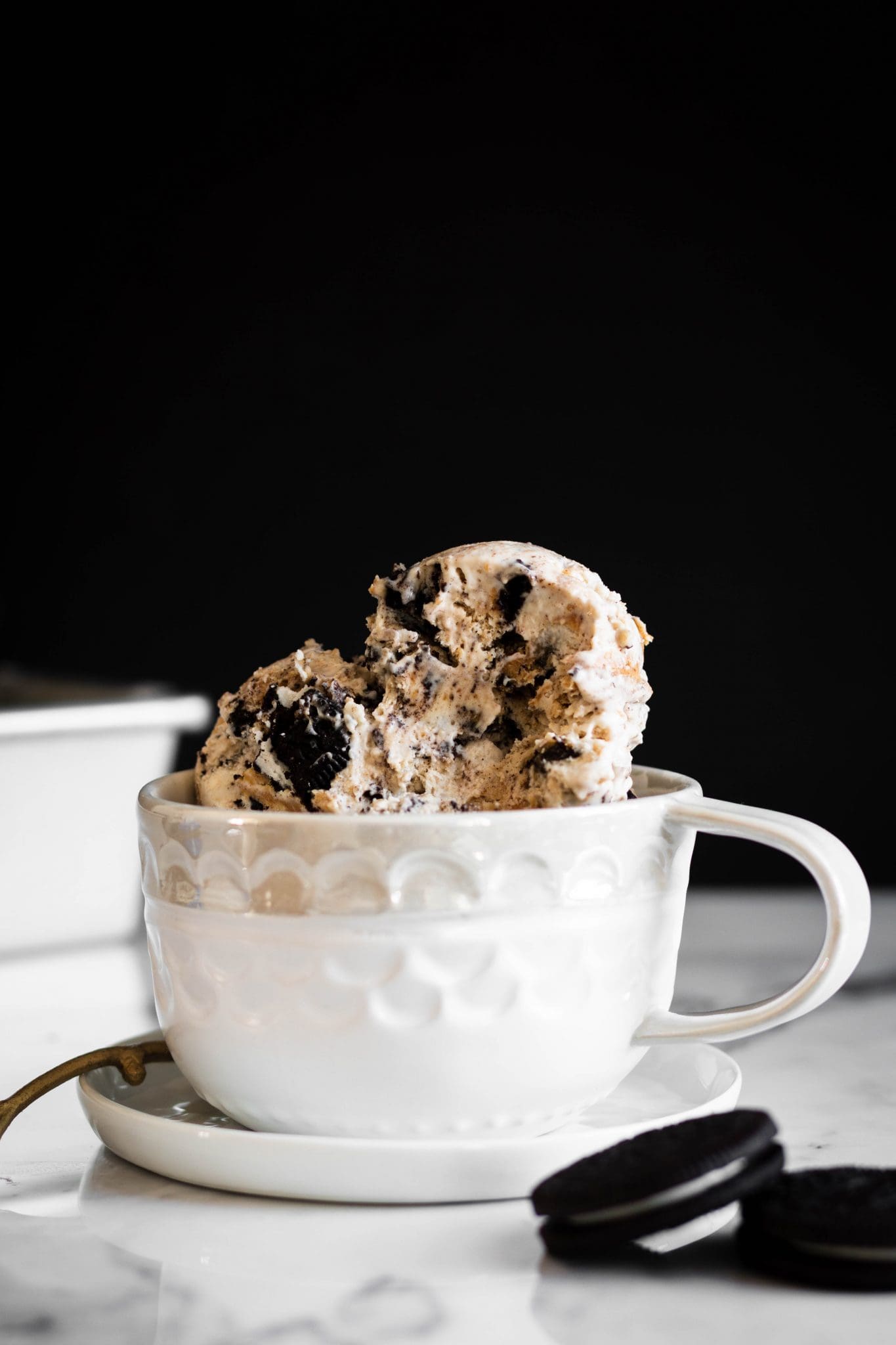 scoops of cookies and peanut butter ice cream in a cup with bite taken