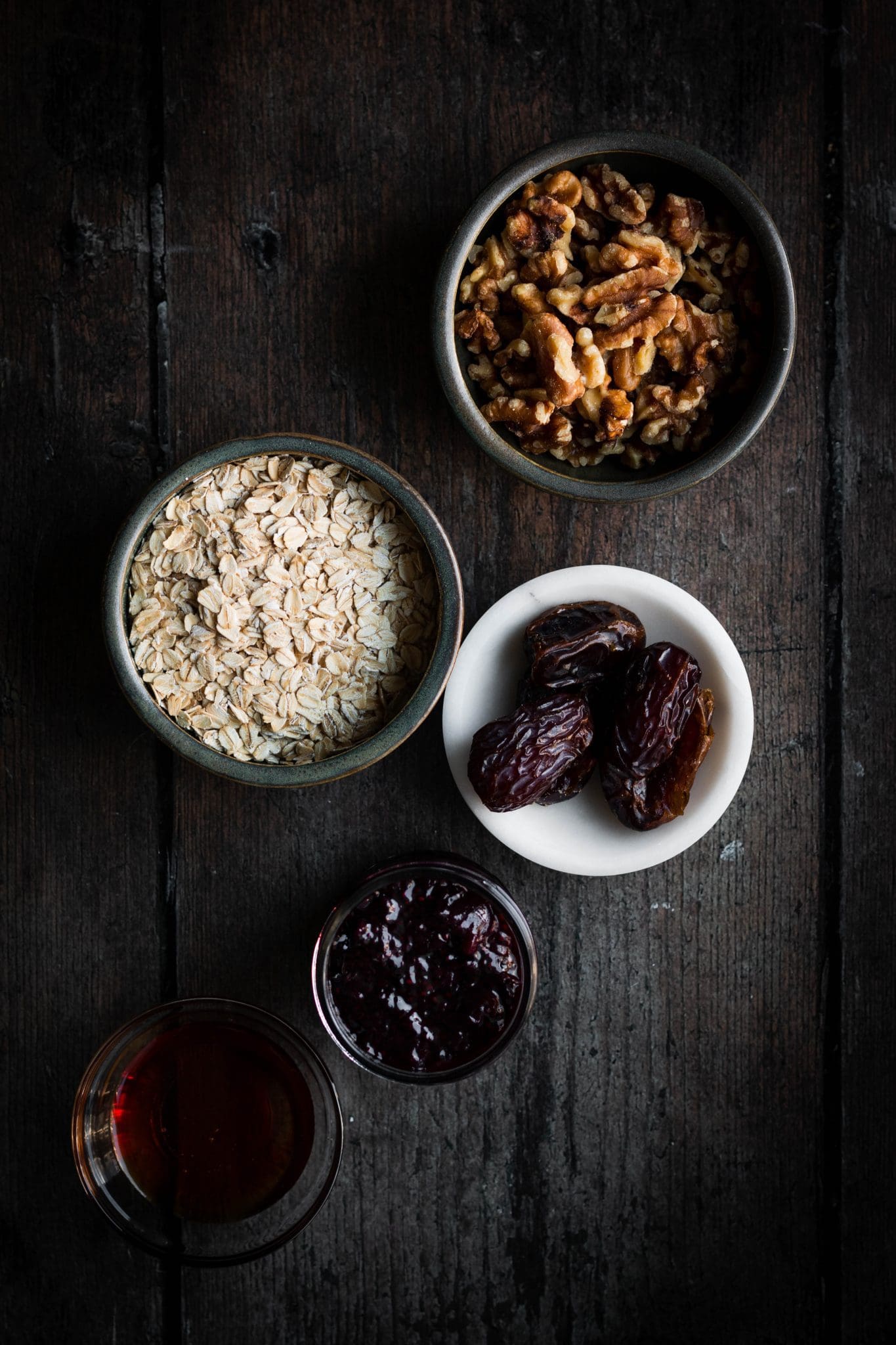 walnuts, oats, dates, jam and maple in bowls