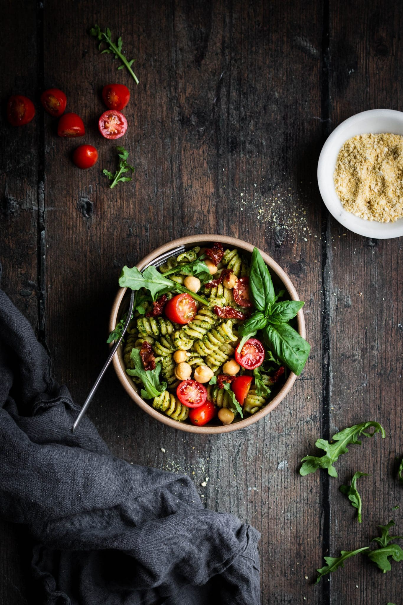 pesto pasta salad with basil, arugula and tomatoes in a bowl