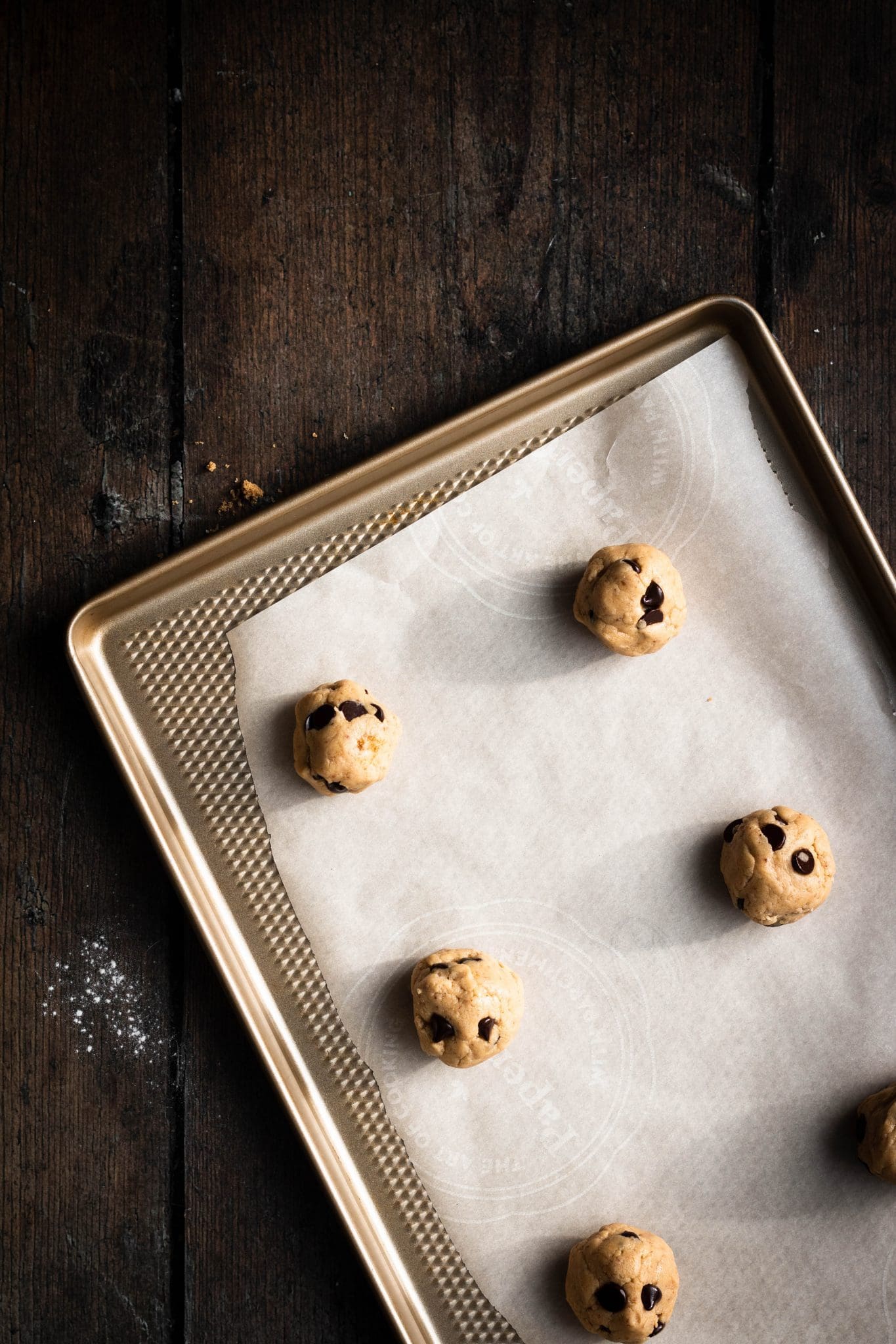 balls of vegan chocolate chip cookie dough on a baking sheet