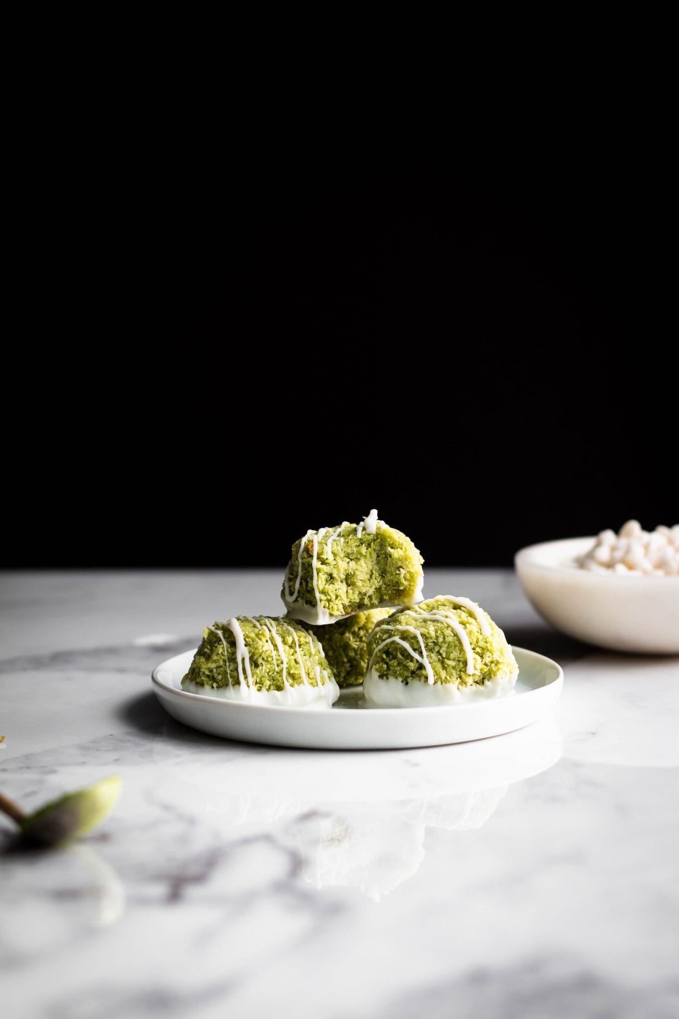 matcha coconut macaroons on a plate with bite taken