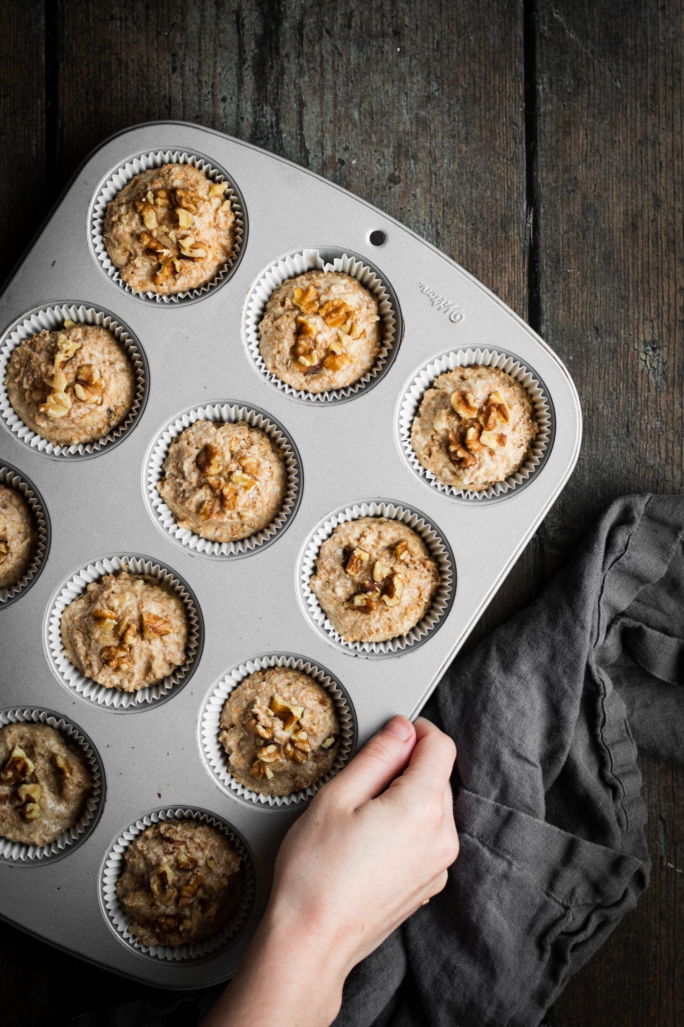 muffin batter with walnuts in a muffin pan