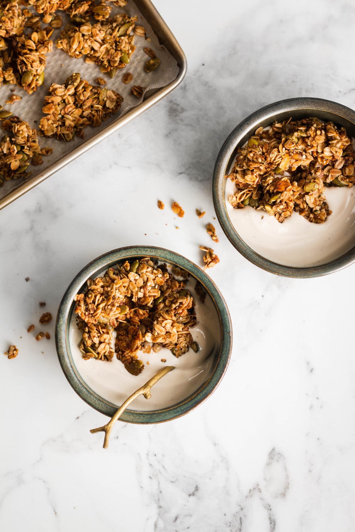 two bowls with yogurt and maple flax pumpkin seed granola seen from the top