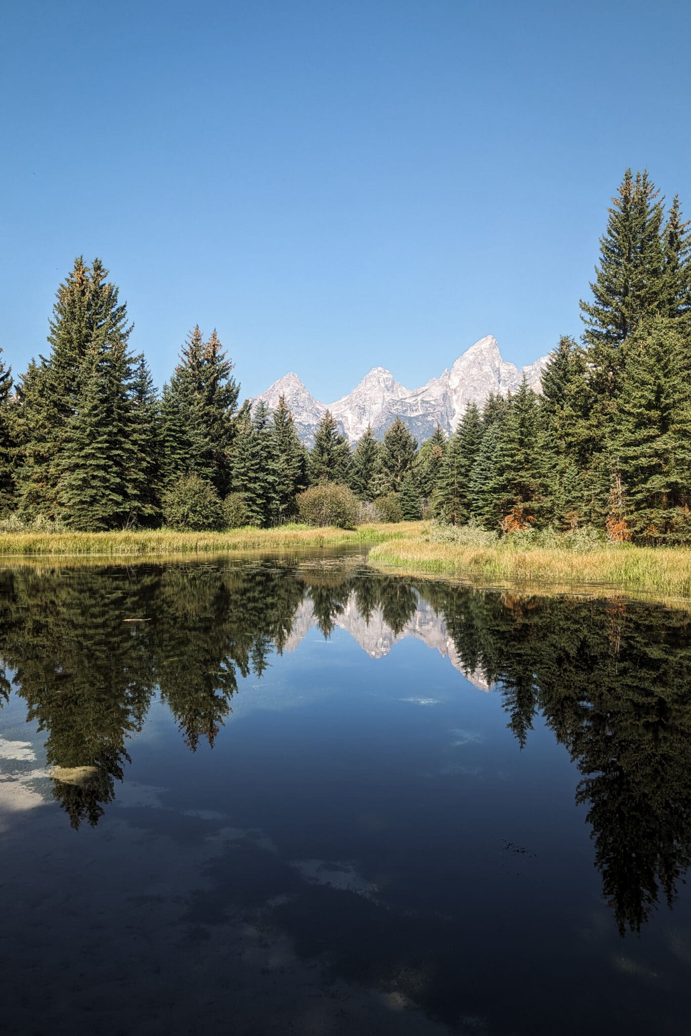 View of Grand Teton Mountains in front of water