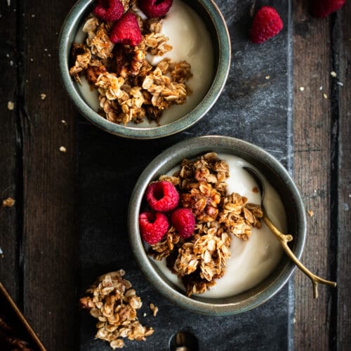 maple walnut granola in bowls with yogurt and raspberries