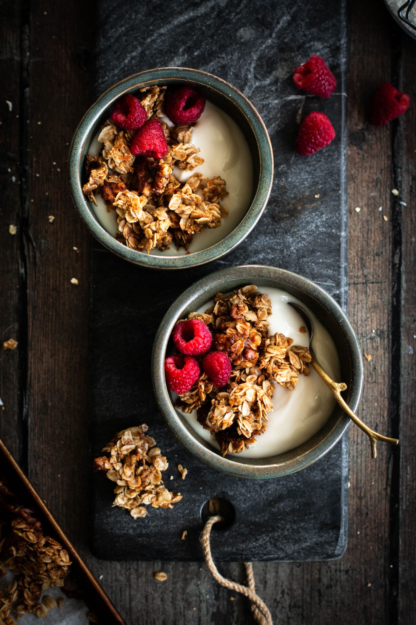 maple walnut granola in bowls with yogurt and raspberries