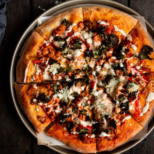 Sliced kale Caesar Buffalo soy curl pizza seen from the top.