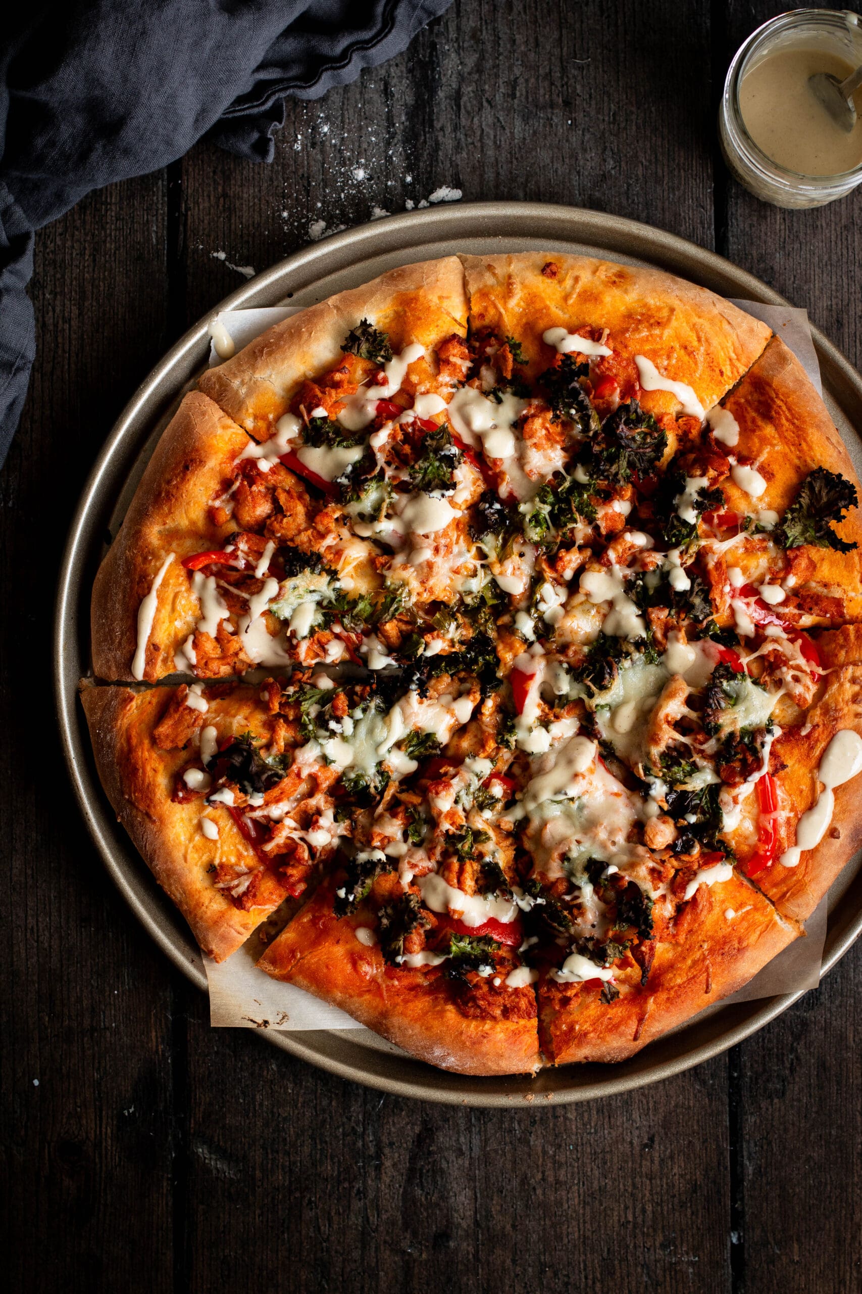 Sliced kale Caesar Buffalo soy curl pizza seen from the top.
