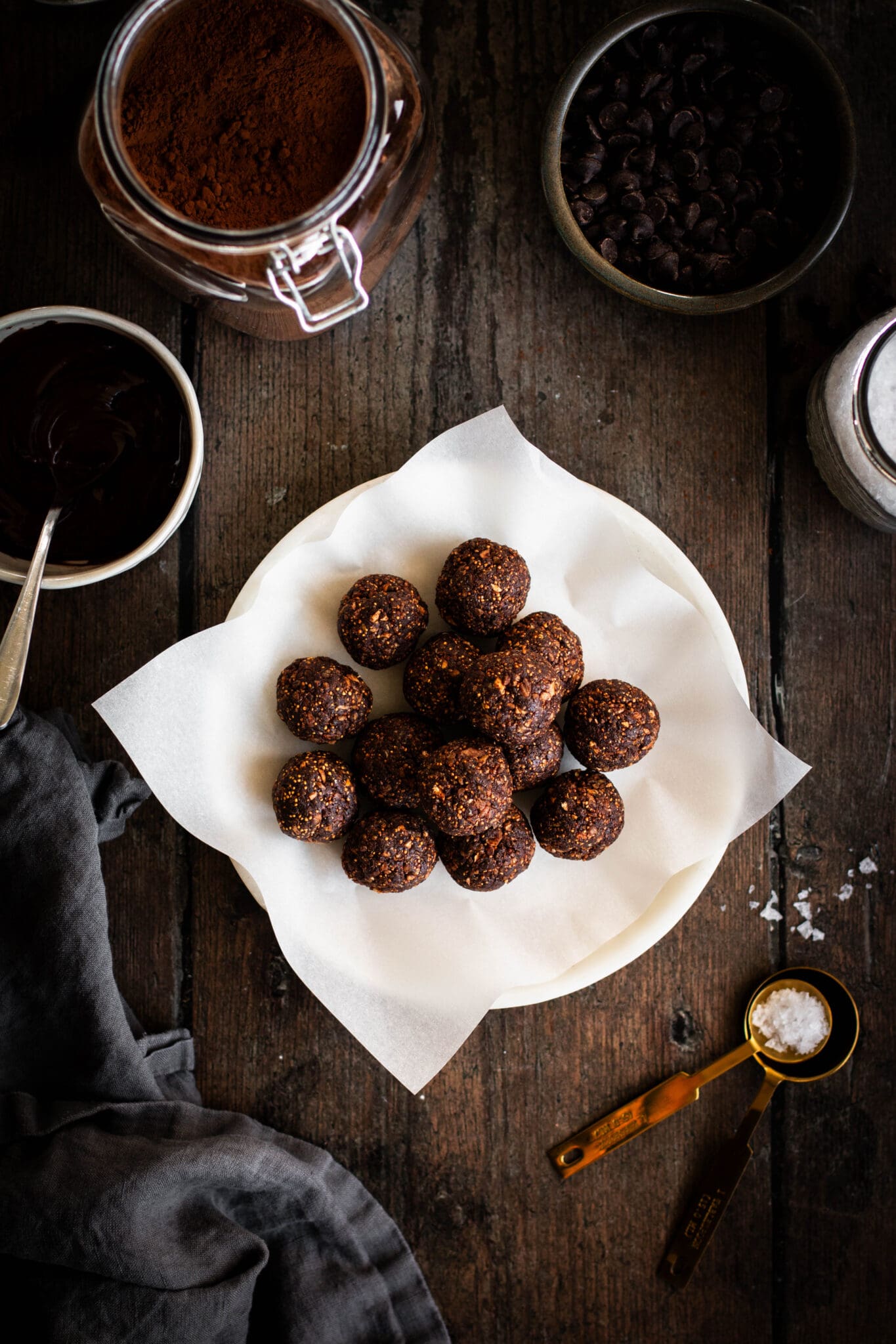 Salted dark chocolate fig truffles on a plate seen from the top.