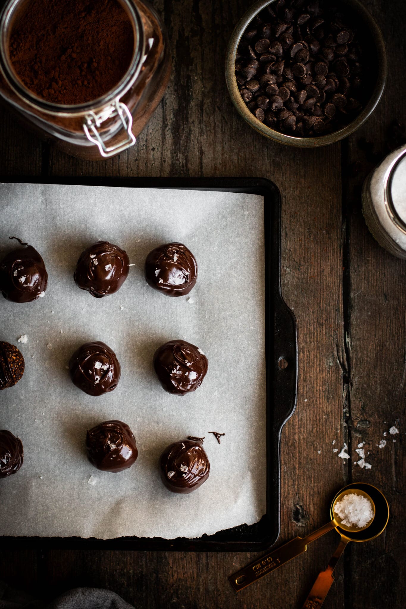 Chocolate dipped fig truffles on a baking sheet.