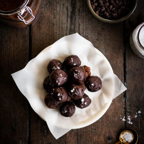 salted dark chocolate fig truffles on a plate seen from the top.