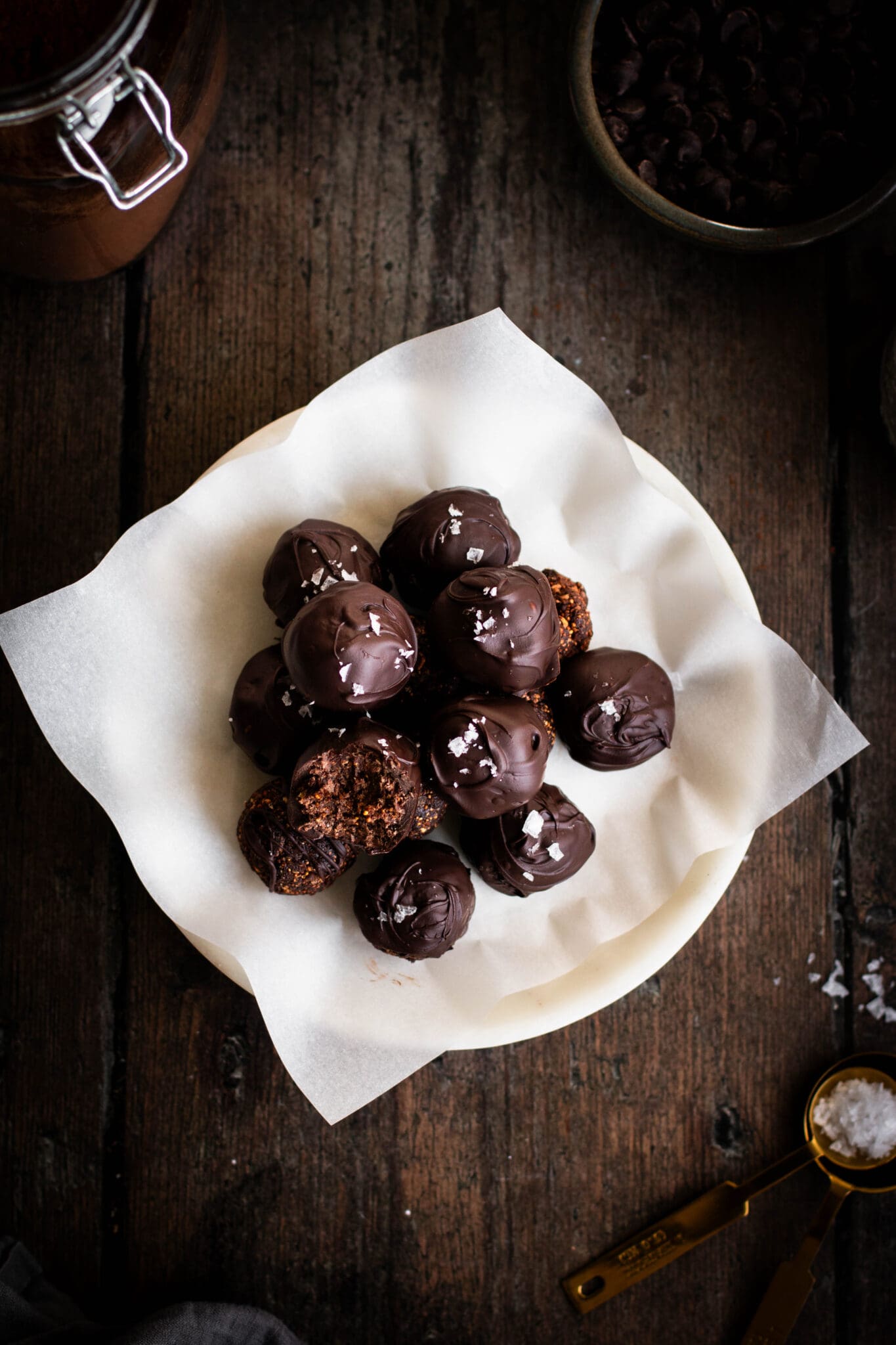 Salted dark chocolate fig truffles on a plate seen from the top.