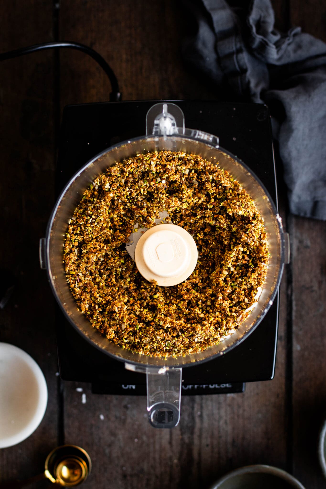 Pistachio energy bite mixture in a food processor seen from the top.