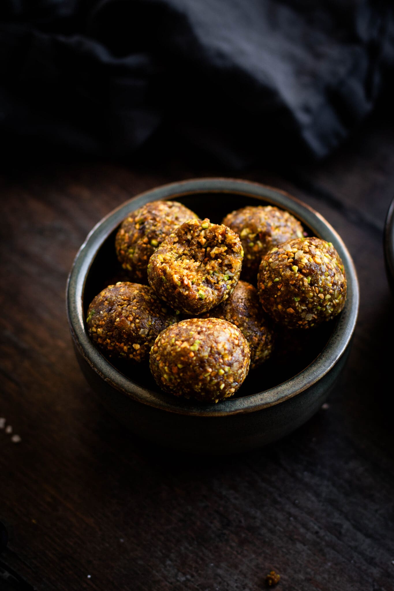 Pistachio energy bites in a bowl seen from the side.