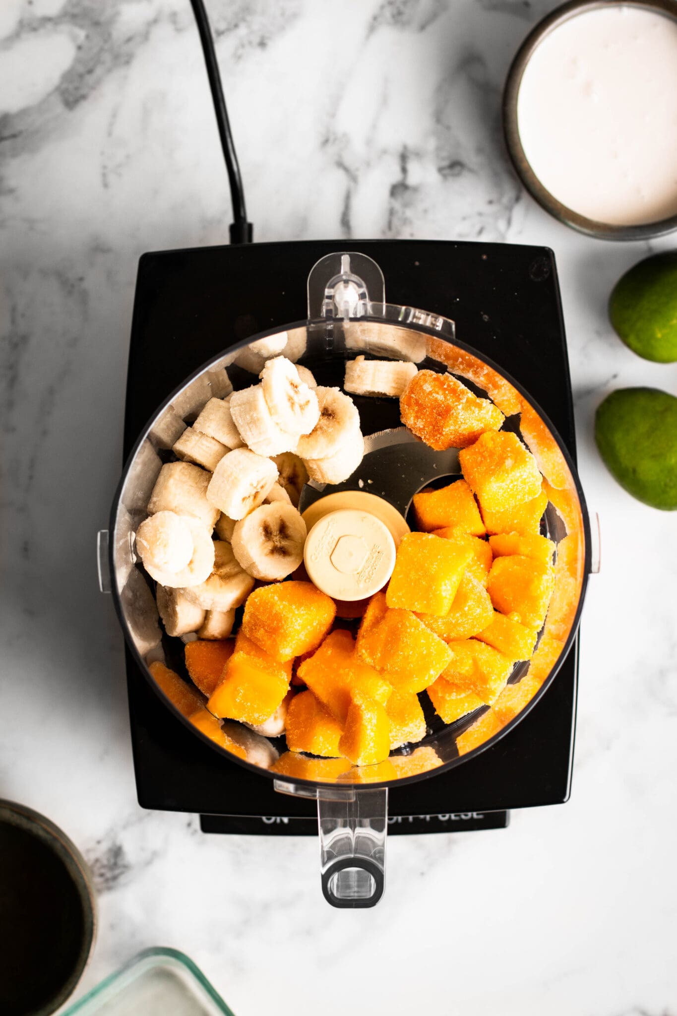 frozen mangoes and bananas in a food processor