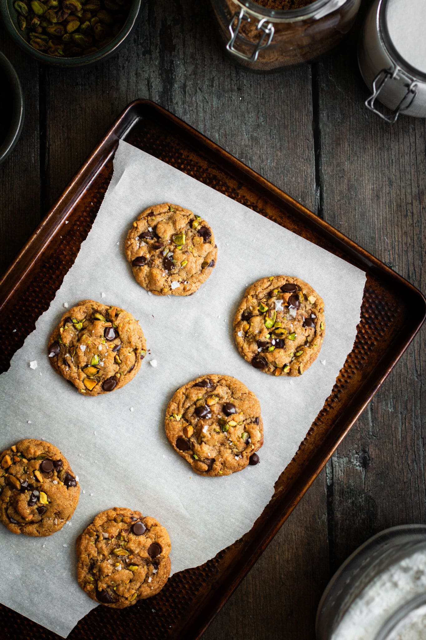 Salted pistachio chocolate chip cookies on a baking sheet.
