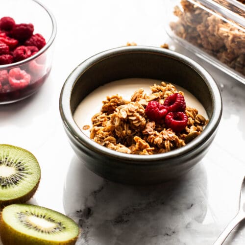 granola, yogurt and fruit bowl with raspberries and kiwi on the side