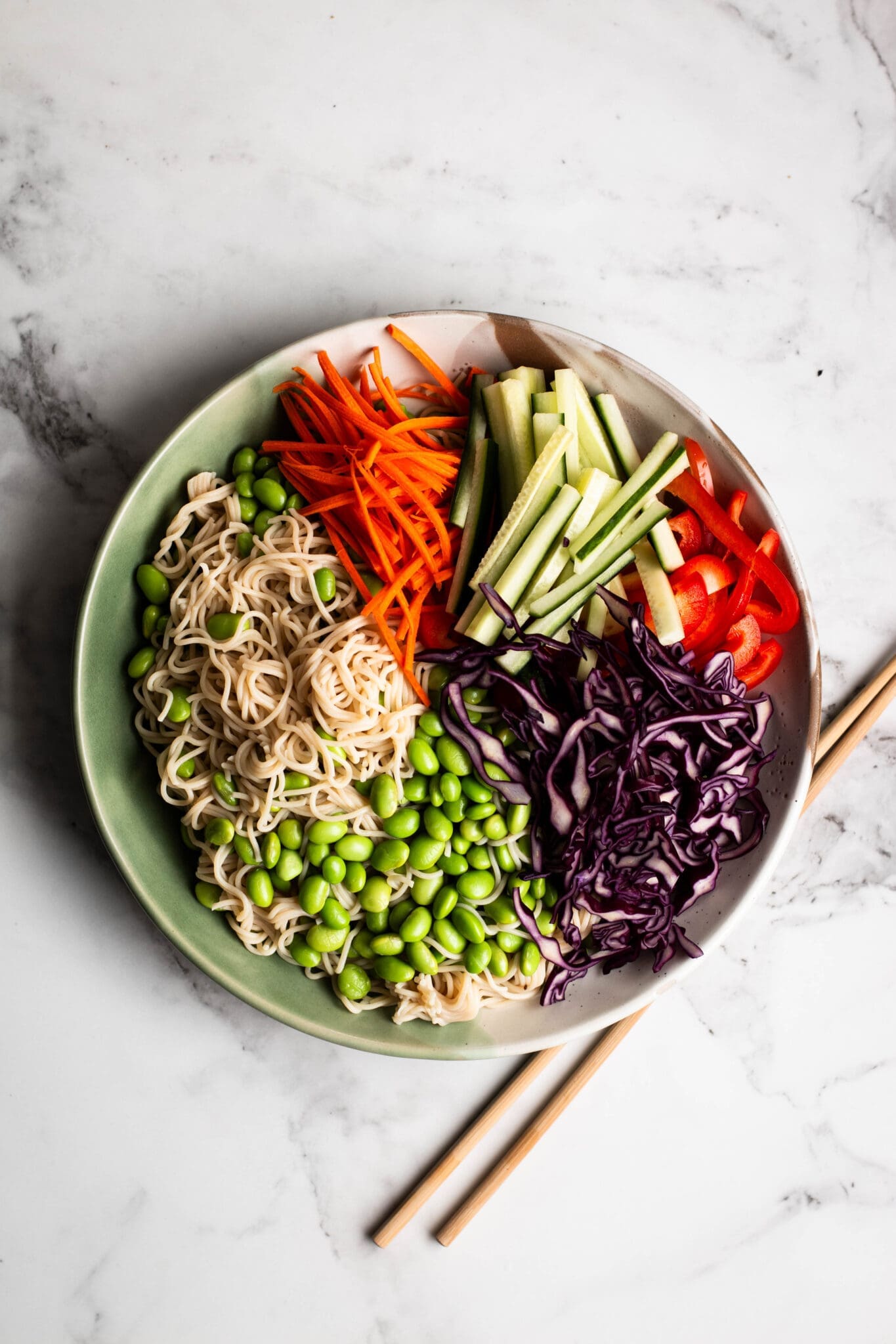 Peanut noodle salad ingredients in a large bowl.